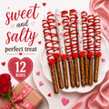 Chocolate-covered pretzel rods with red drizzle, roses and heart decorations